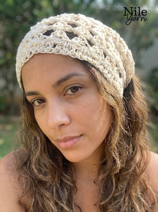 Woman wearing a beige crochet headband done by Nile Yarn 