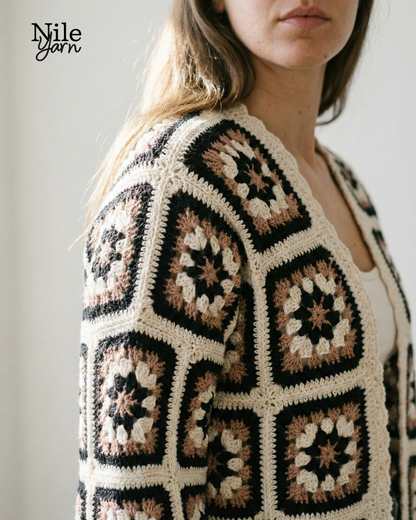 Woman wearing a crocheted patterned cardigan with 'Nile Yarn' branding.
