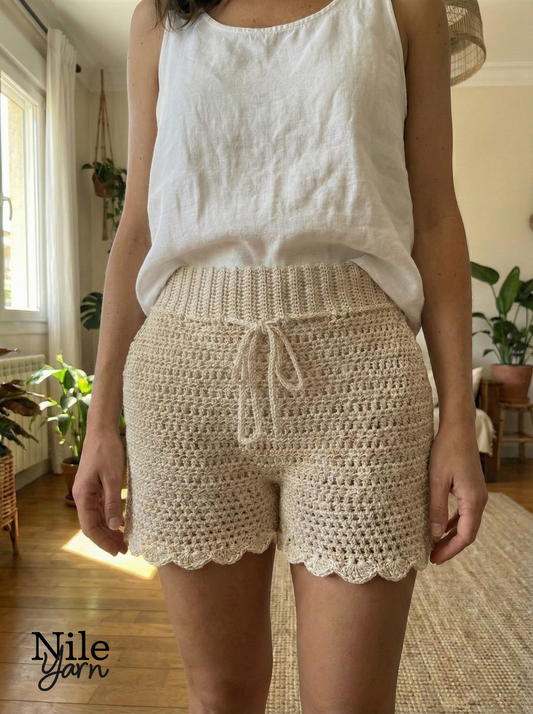 Model wearing a white top and beige undyed crochet shorts made by Nile Yarn Neith 
